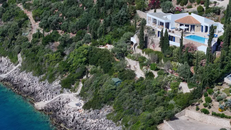 Aerial view of the wooded hillside dropping to a sheltered cove