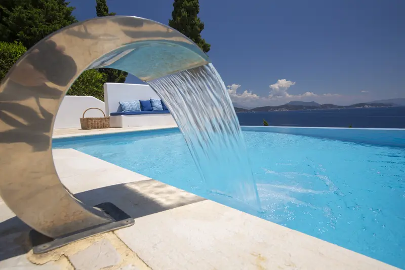 Water spilling from a stone spout into the pool