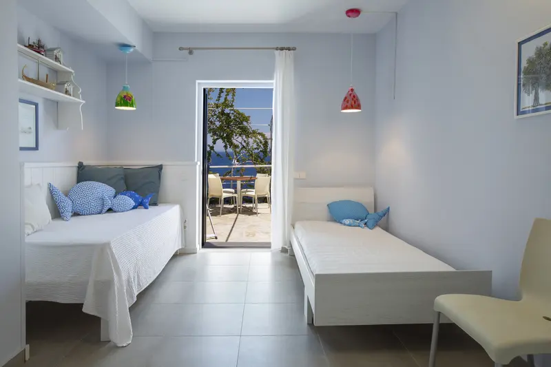 Children’s bedroom with twin beds under a sloped beamed ceiling