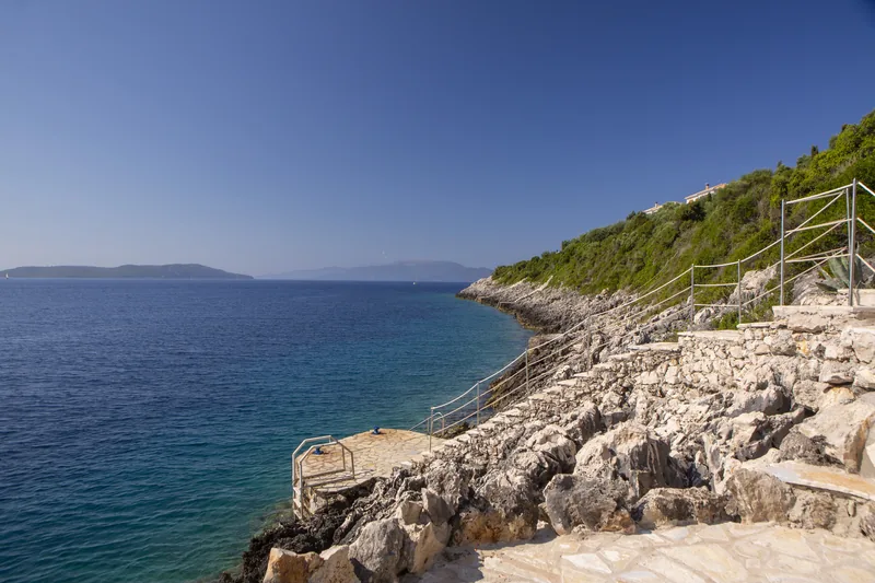 Rocky shoreline and open sea with the cliff path leading down to the water